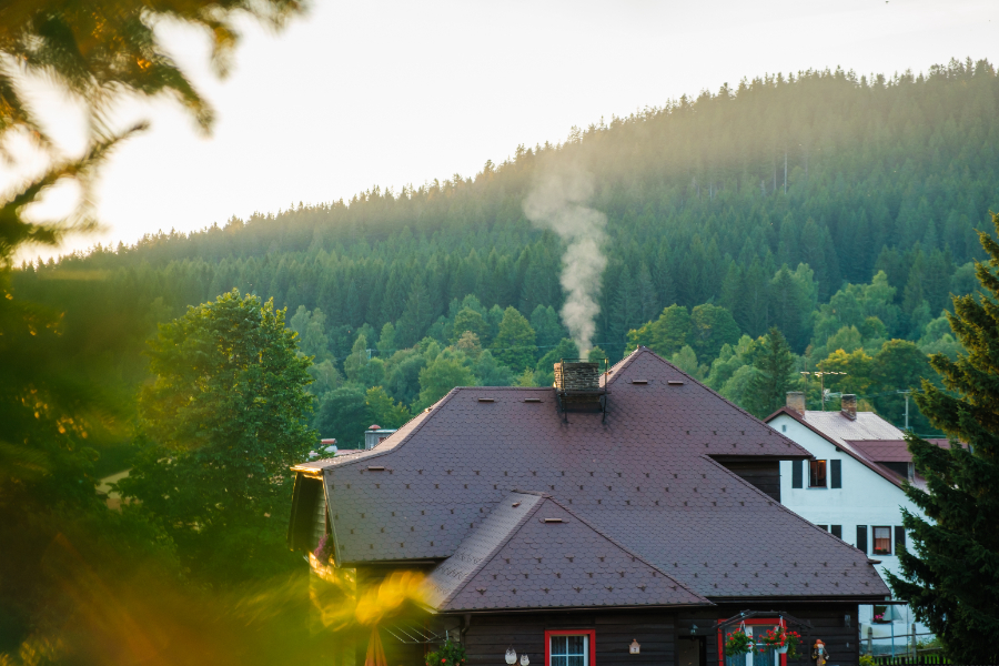 Il y a de la fumée blanche qui sore de la cheminée d'une maison