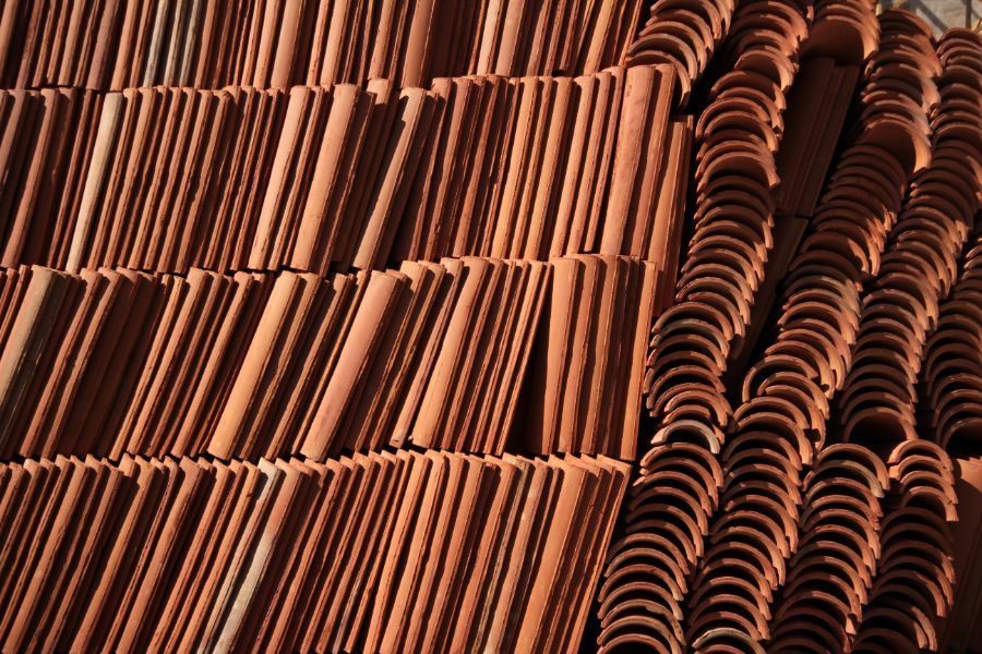 Comparatif visuel entre trois types de tuiles avec leurs prix au m² affichés sous forme de tableau