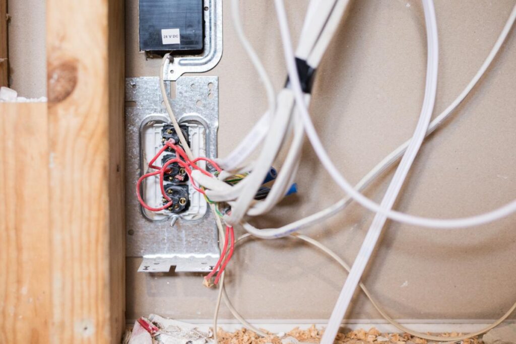 Un boîtier d’encastrement rempli de fils montre un montage en série et en dérivation