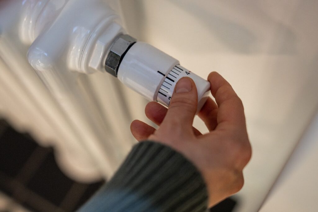 Une personne effectuant une vérification du serrage du robinet d'un radiateur