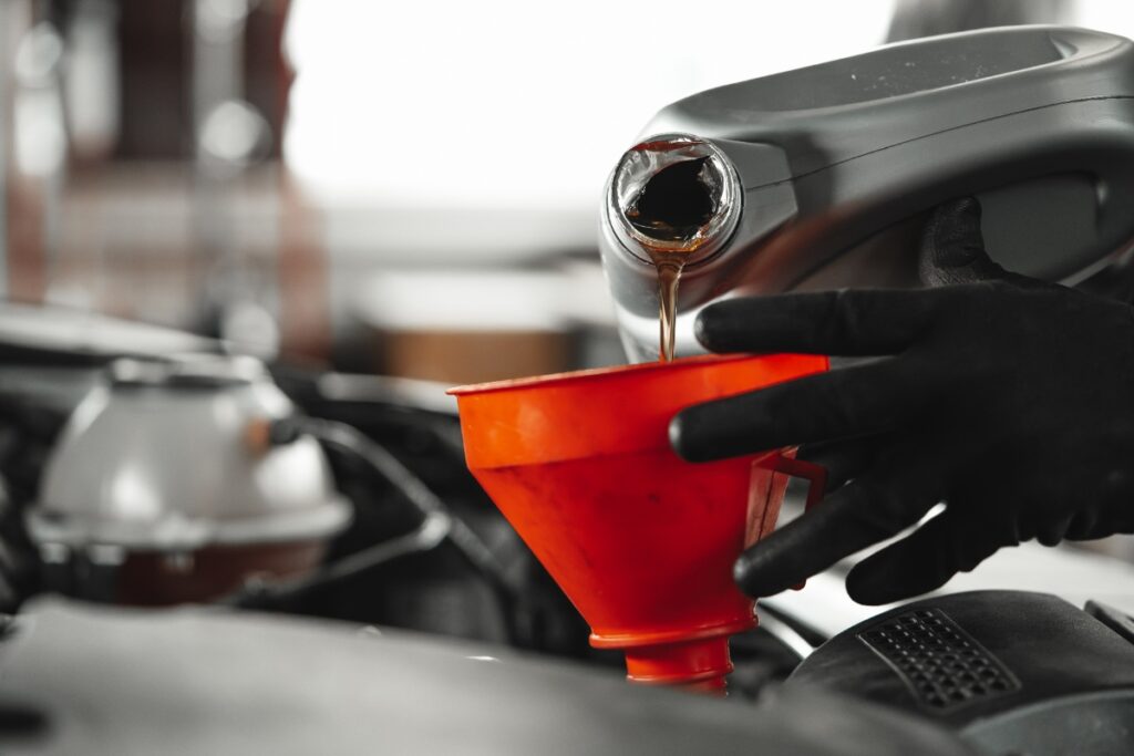 Une personne qui verse de l'huile compresseur 