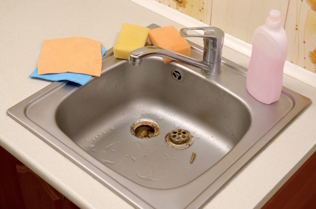 Un évier de cuisine inox avec des produits de nettoyage