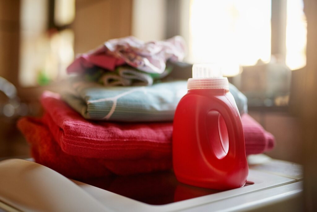 Une bouteille rouge d'eau écarlate placée à côté des linges