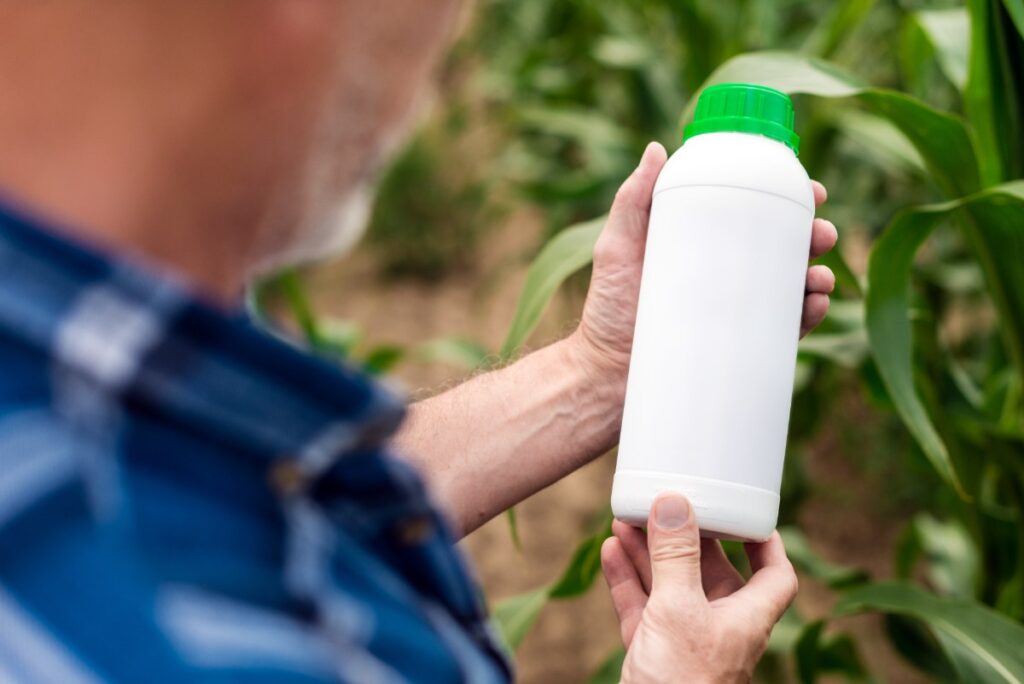 Un homme inspectant une bouteillle de garlon
