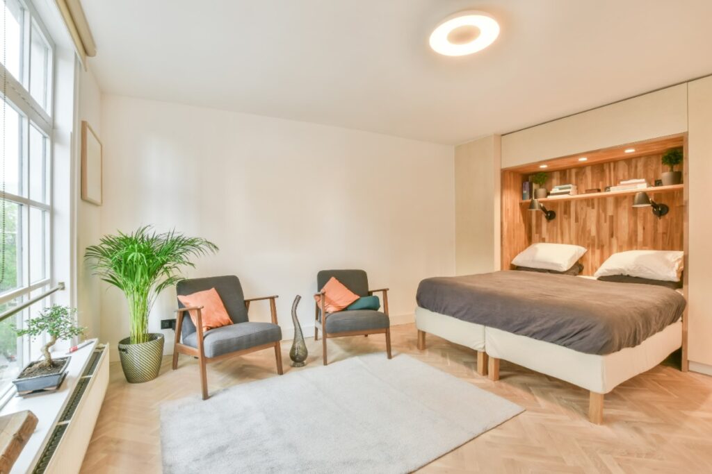 Une chambre avec un lit, des chaises et des plantes