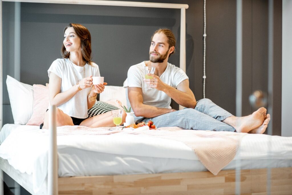 Un couple heureux buvant du thé sur le lit