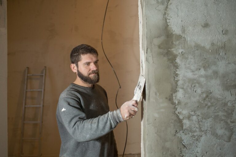 Un homme barbu enduisant le mur