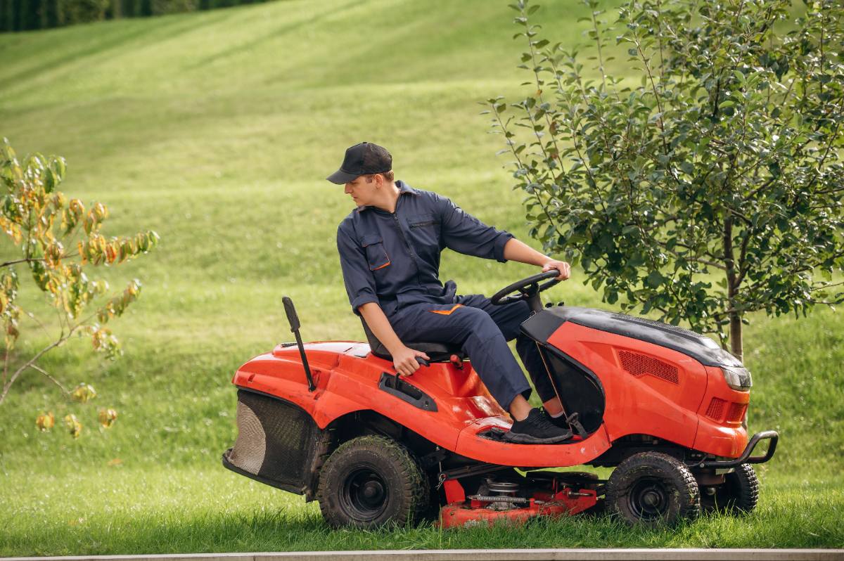 Un homme conduisant une tondeuse kubota