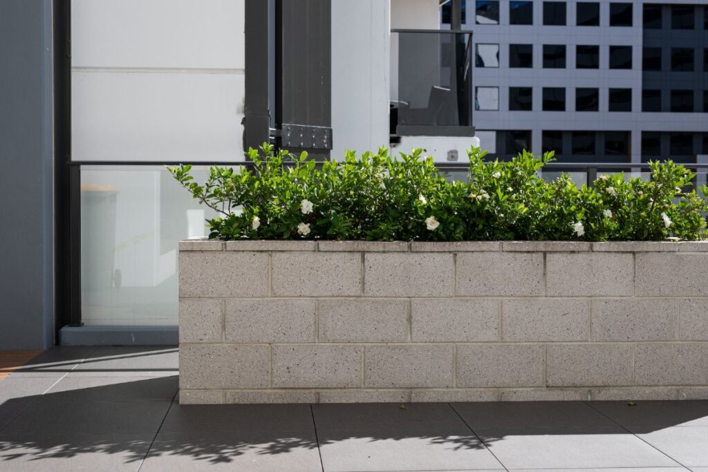 Une jardinière en parpaing avec des plantes vertes