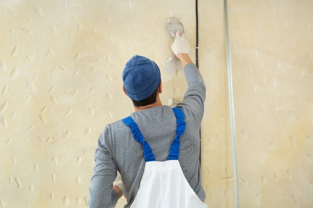 Un ouvrier appliquant de l'enduit sur le mur