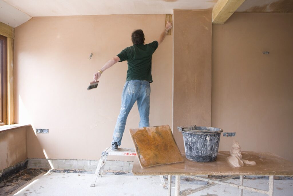 Un ouvrier enduisant le mur intérieur