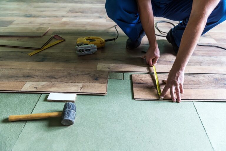 Un ouvrier installant du nouveau plancher en bois