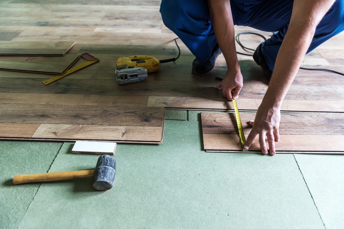 Un ouvrier installant du nouveau plancher en bois