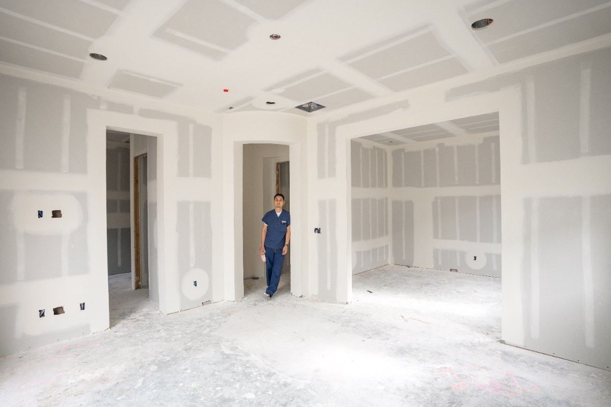 Un homme en uniforme bleu dans une maison en rénovation