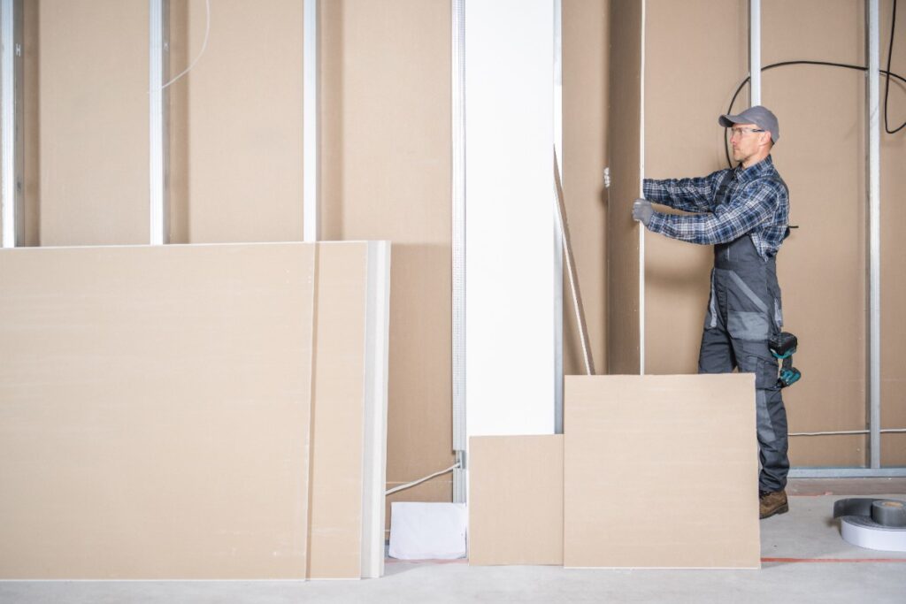 Un ouvrier installant une cloison en placo