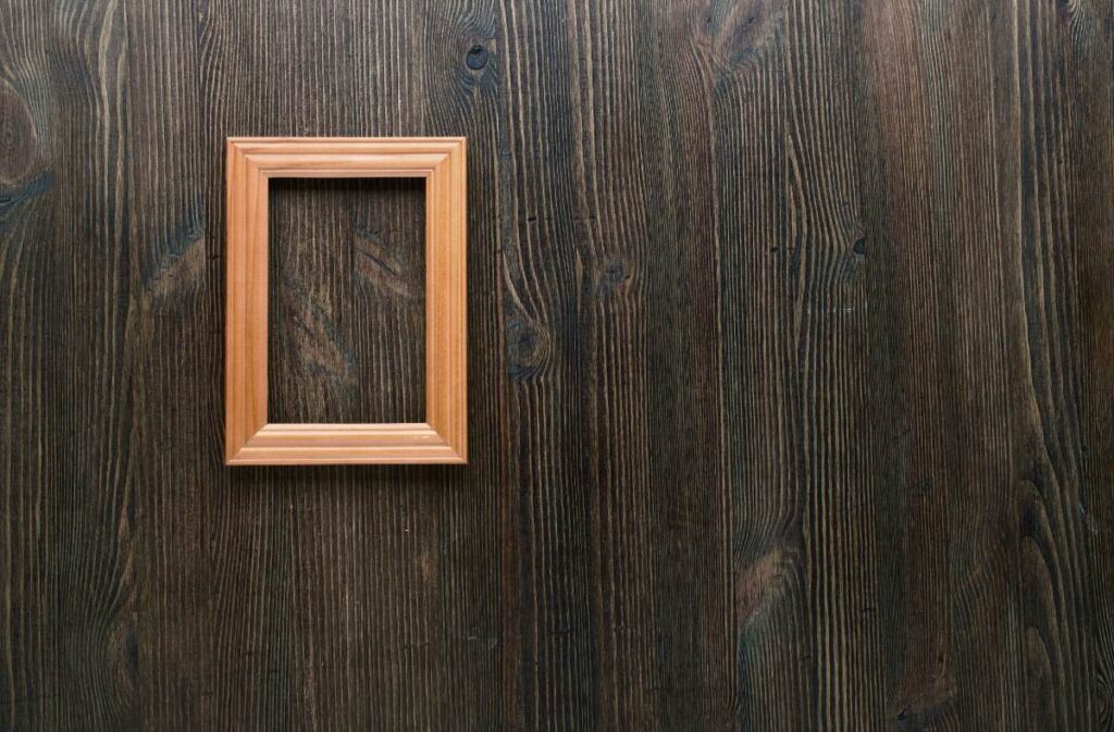 Un cadre vide accroché à une cloison en bois brulé