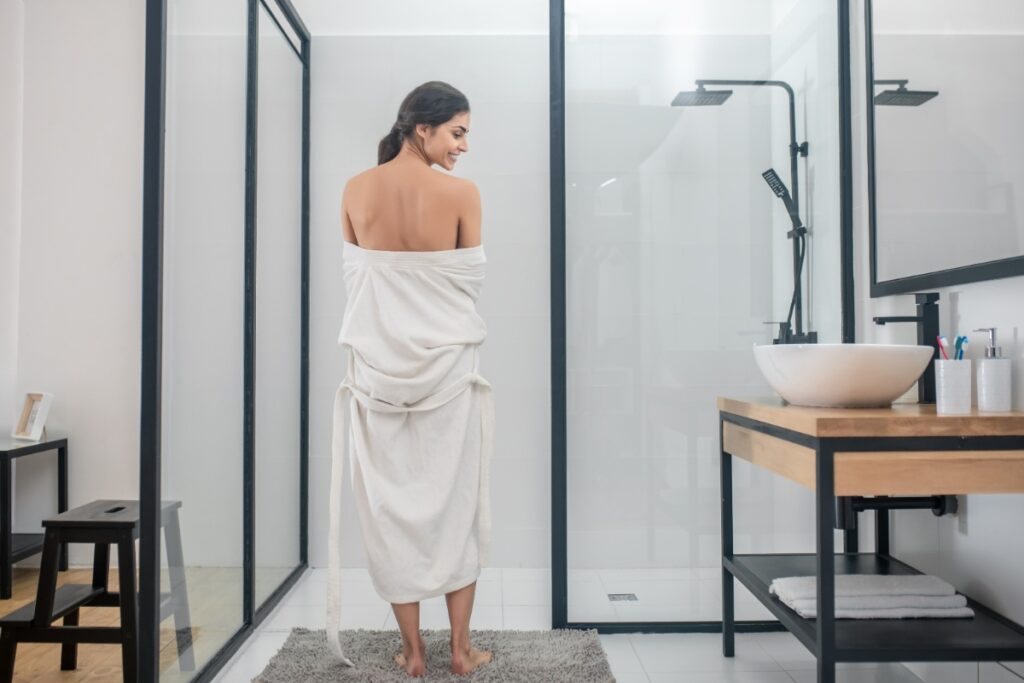 Une femme en serviette dans la salle de bain
