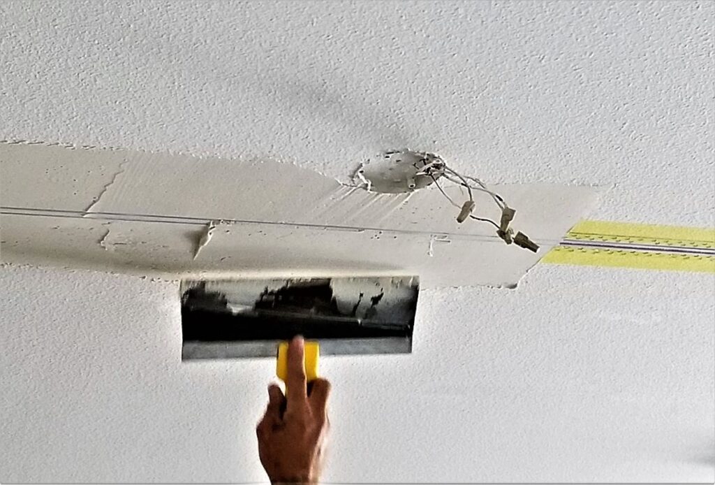 Une personne faisant un plâtrage de plafond