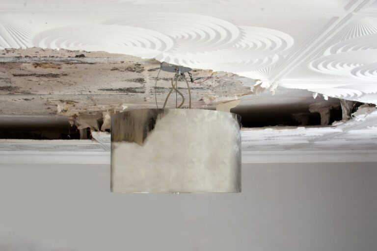 Un plafond endommagé avec une lampe décorative