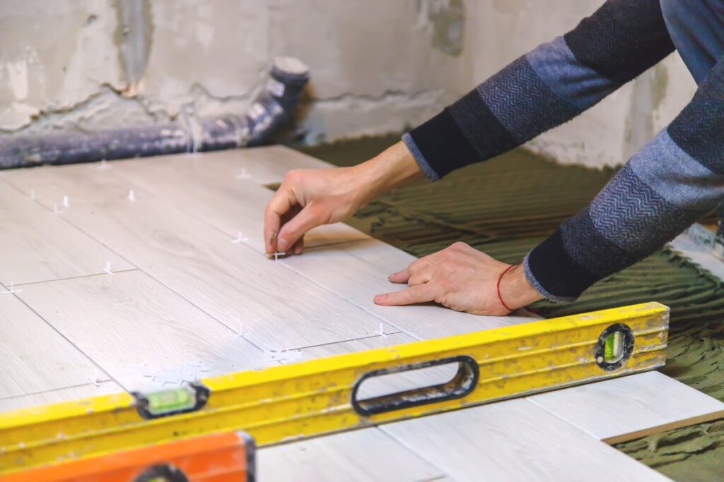 Un homme travaillant pour une pose de carrelage imitation bois