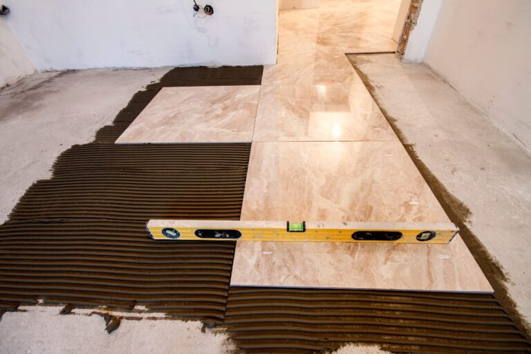 Pose de carrelage avec du mortier brun