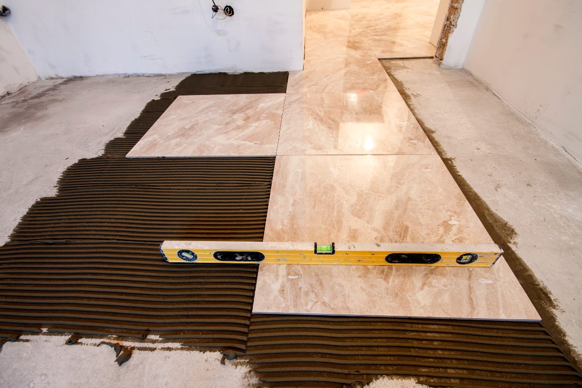 Pose de carrelage avec du mortier brun