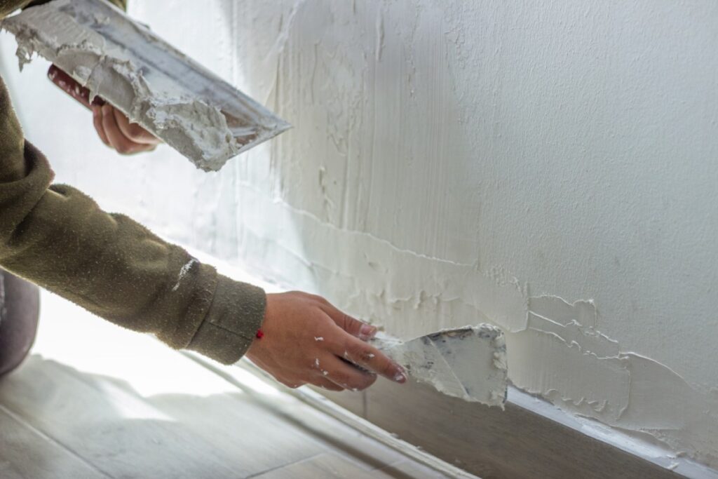 Un homme appliquant de l'enduit sur le mur