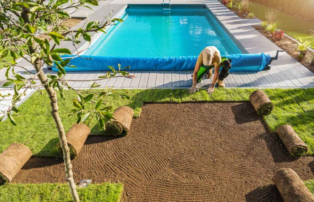 Un homme posant de nouveau gazon près de la piscine