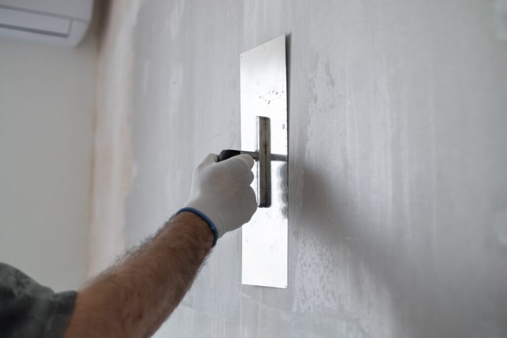 Un ouvrier appliquant de l'enduit sur le mur