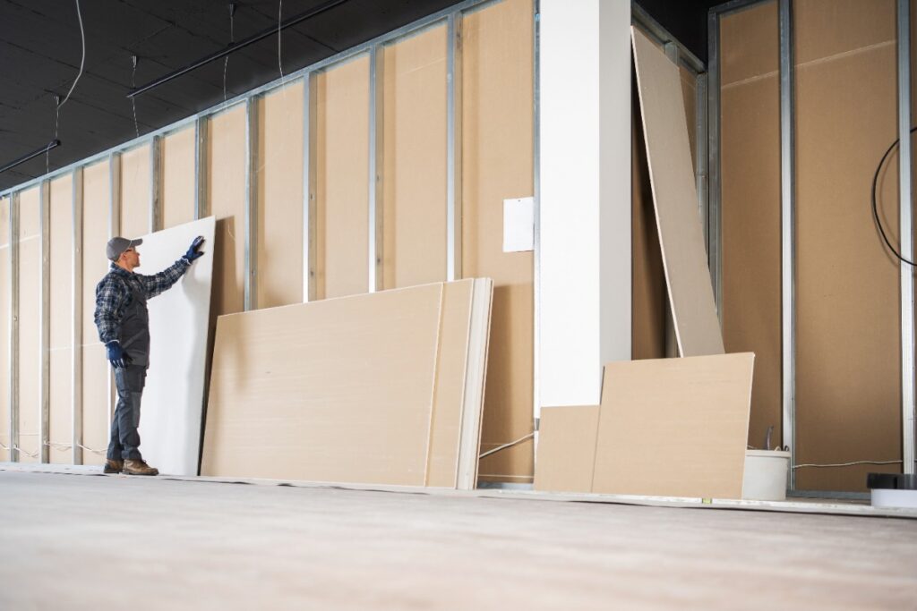 Un ouvrier inspectant des plaques de placo pour la cloison